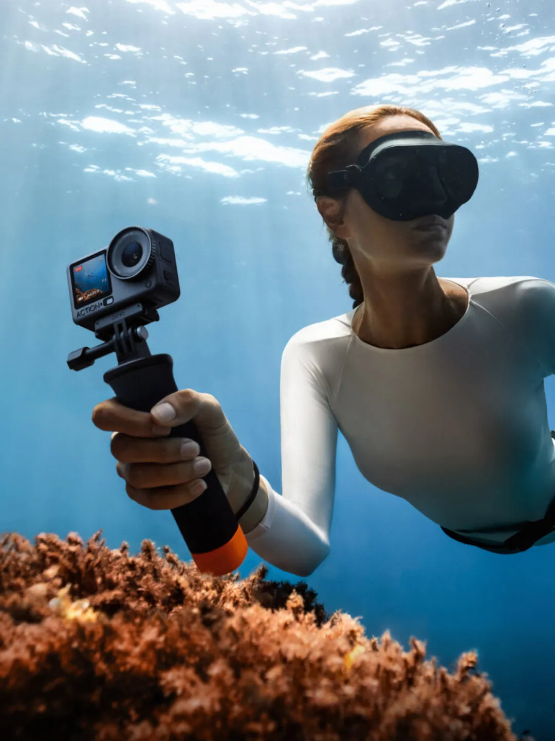 Woman underwater holding a waterproof action camera with black goggles | Altitude Philippines