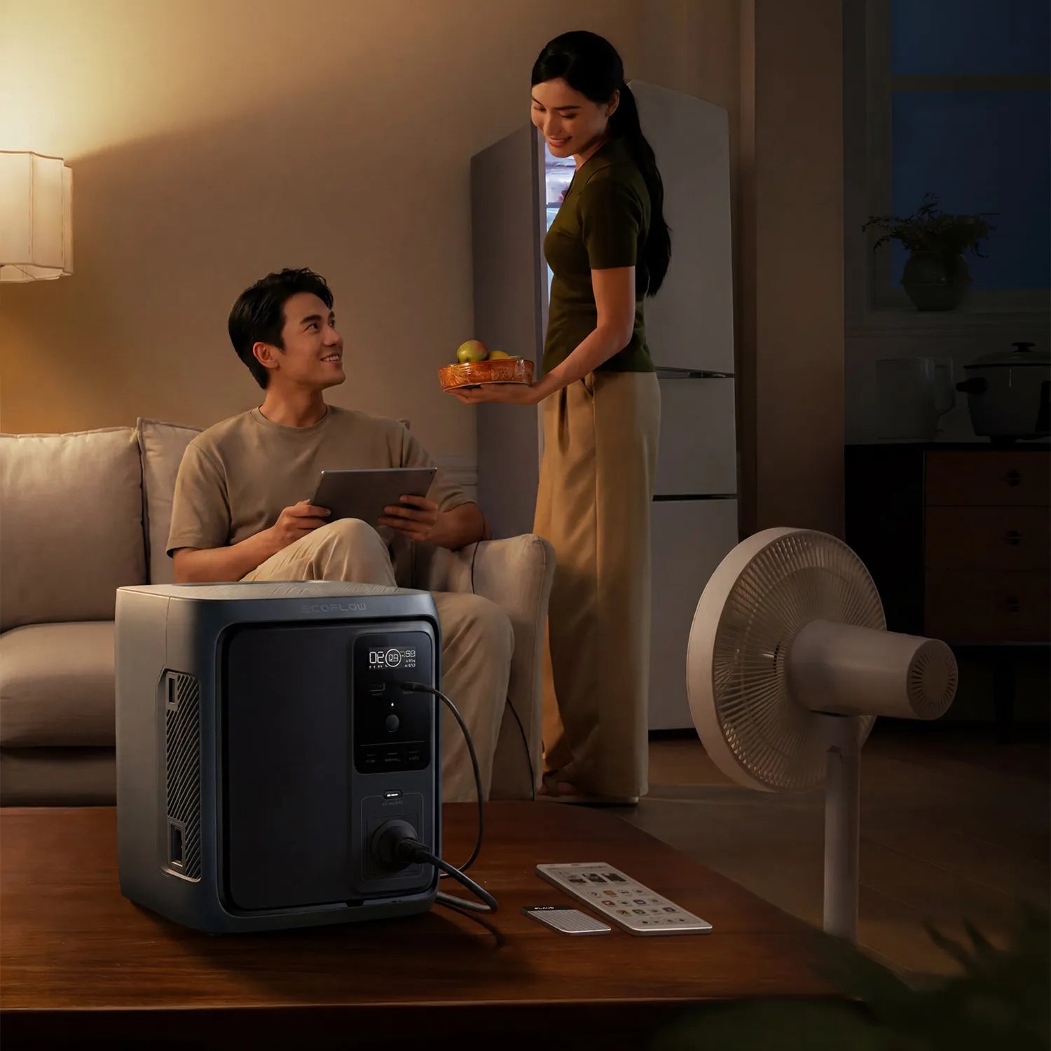 Man using a tablet while a woman brings fruits, with a power generator and fan in the background | Altitude Philippines
