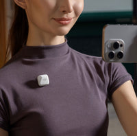 Vlogger recording on an iphone with DJI Mic Mini Transmitter attached to her shirt