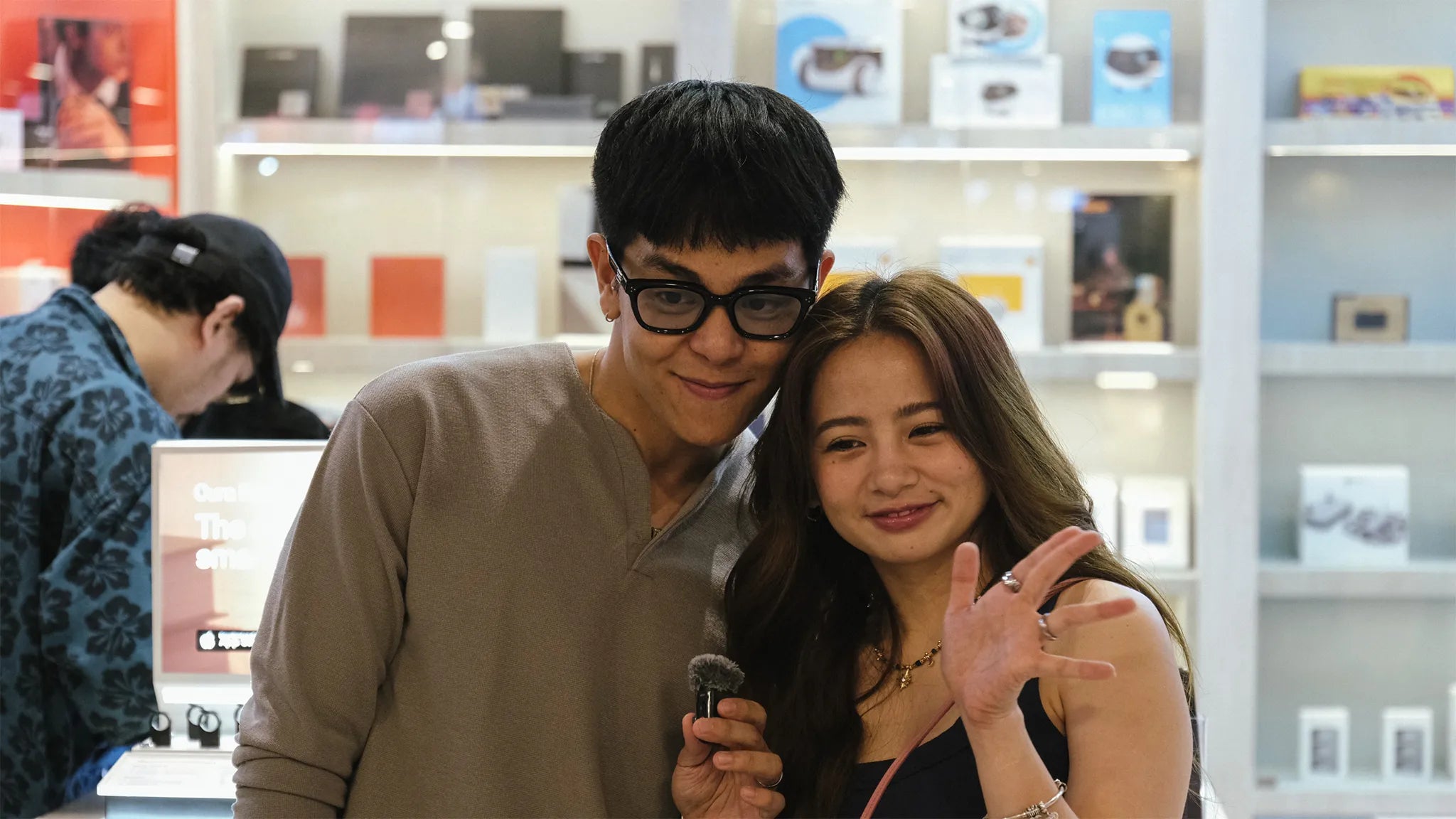 Couple posing with a wireless microphone inside a tech store | Altitude Philippines