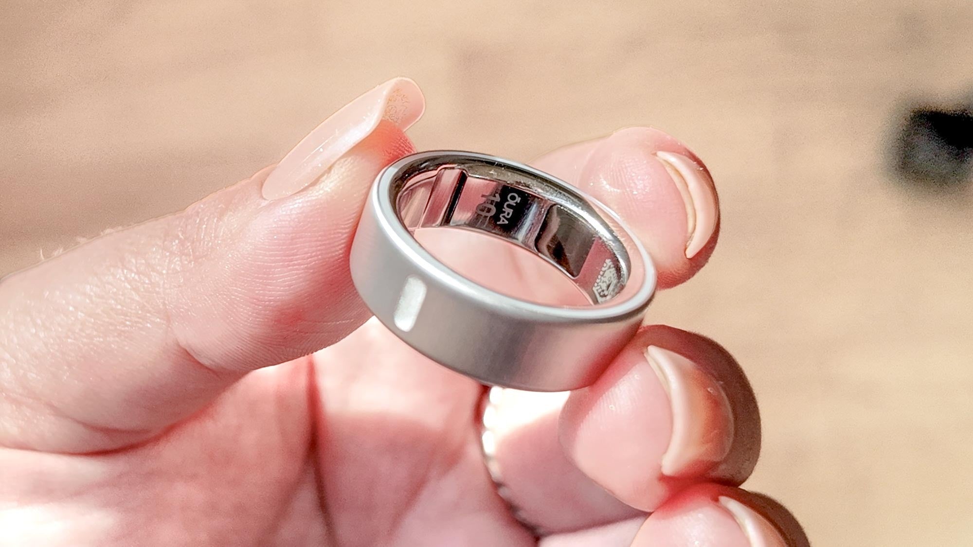 Close-up of a hand holding a silver Oura Ring in bright natural sunlight | Altitude Philippines