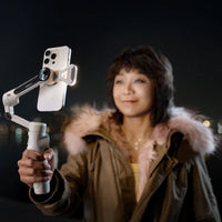 Girl taking a selfie with phone mounted on the Insta360 Flow 2 Pro Spotlight