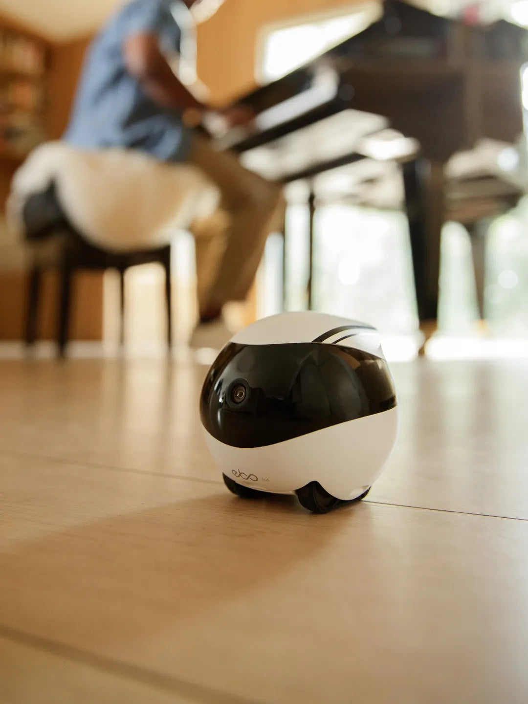 Small smart monitoring robot on a wooden floor with a blurred indoor background | Altitude Philippines