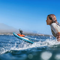 Girl surfing with Insta360 camera secured on board using Floating Surfboard Mount