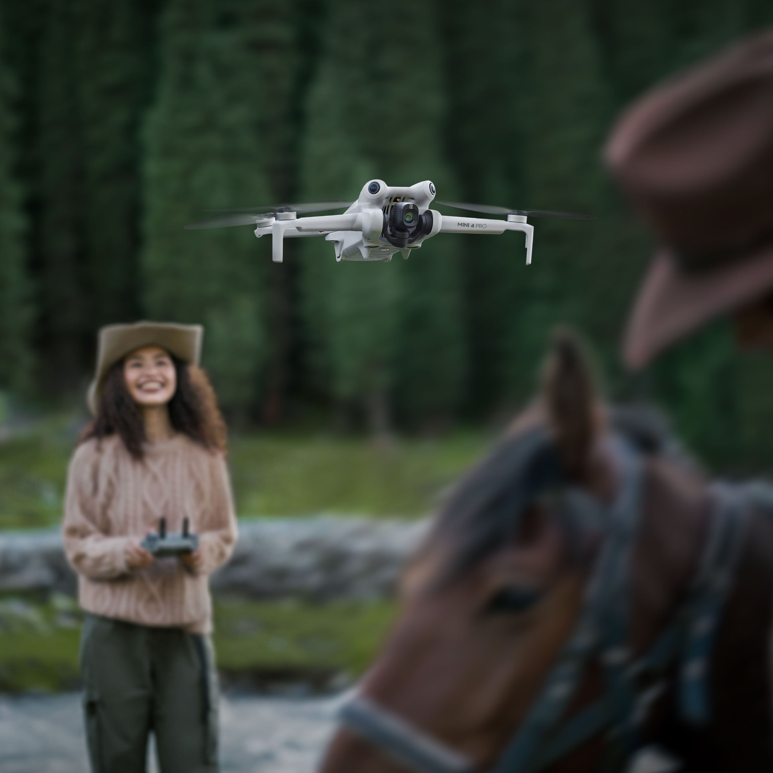 DJI Mini 4 Pro being flown using a remote by a woman